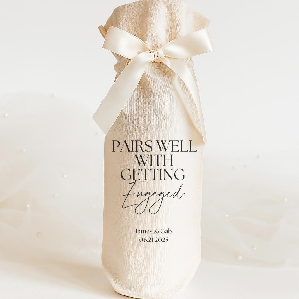 Wine gift bag with a bow and personalized text on a white background "Pairs Well With Getting Engaged" 